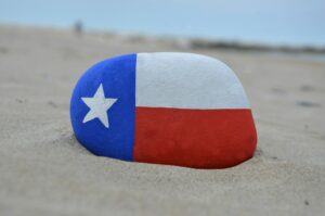 Texas flag painted on a stone over the sand